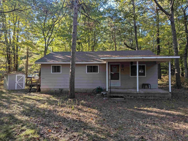 view of front of property featuring covered porch and a shed