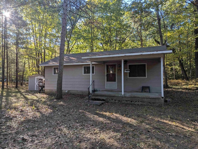 ranch-style house with a porch and a storage shed