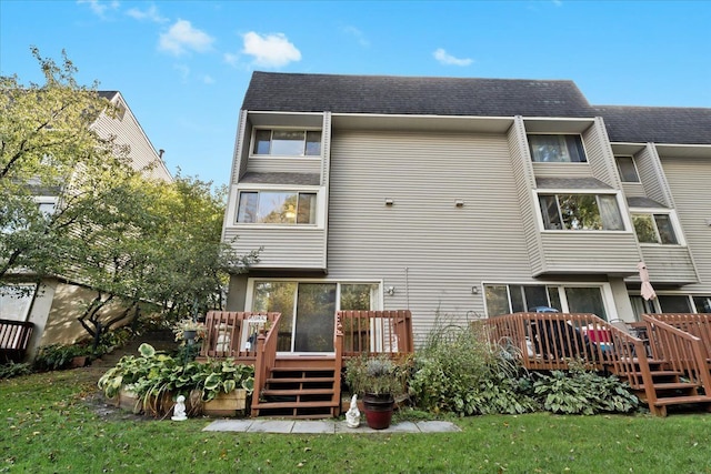 back of house with a deck and a yard