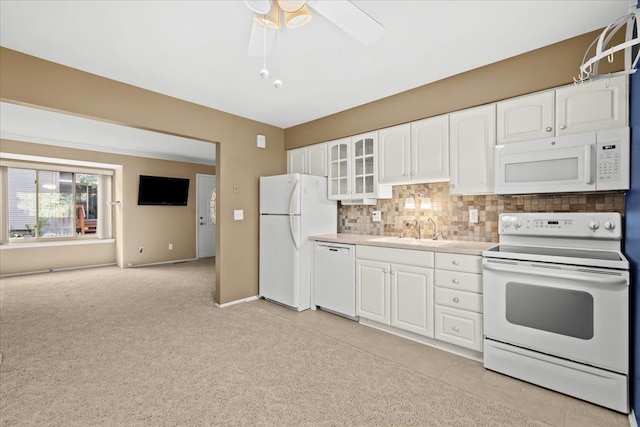 kitchen featuring white appliances, backsplash, sink, light tile patterned floors, and white cabinetry