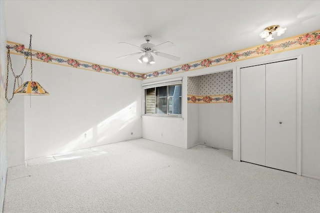 unfurnished bedroom with ceiling fan, a closet, and carpet