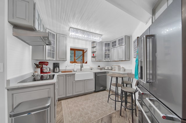 kitchen featuring sink, gray cabinets, appliances with stainless steel finishes, tasteful backsplash, and light hardwood / wood-style floors