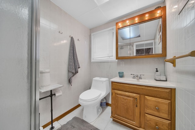 bathroom with tile patterned floors, vanity, tile walls, and walk in shower