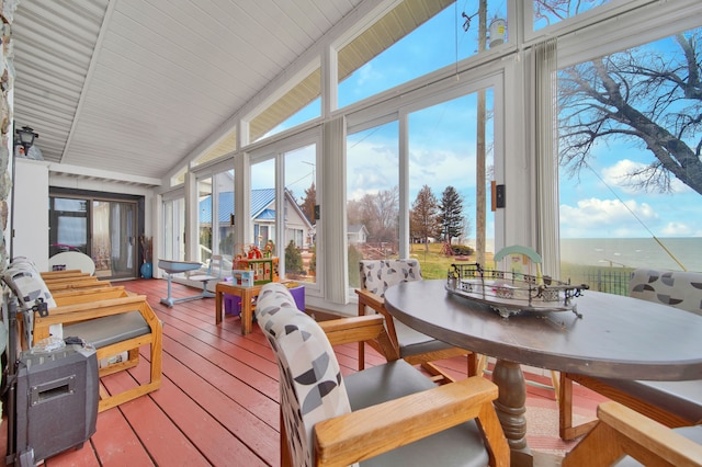 sunroom / solarium featuring a water view, plenty of natural light, and lofted ceiling