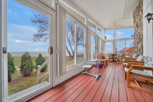 sunroom / solarium featuring a water view and ceiling fan