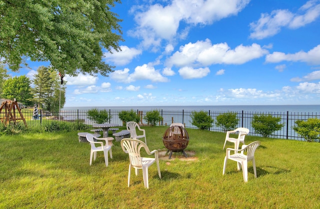 view of yard with a water view and an outdoor fire pit