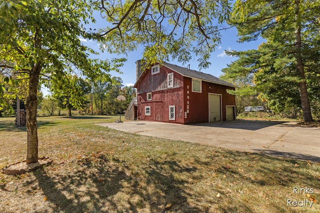 view of home's exterior featuring a lawn and an outdoor structure