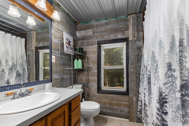 bathroom with vanity, toilet, tile walls, and wooden walls