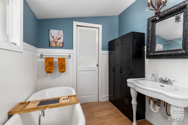 bathroom featuring hardwood / wood-style floors, a tub, and lofted ceiling