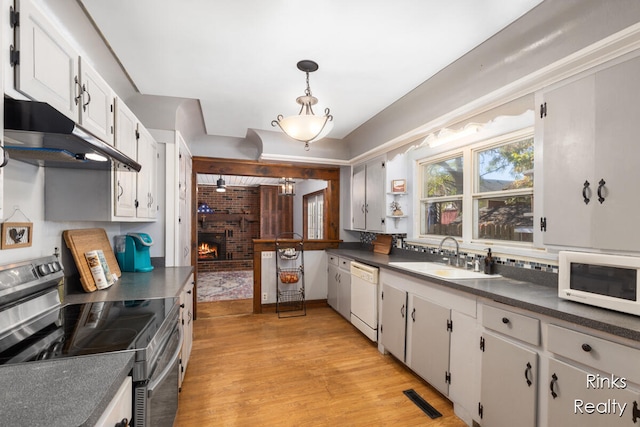 kitchen featuring a brick fireplace, white appliances, sink, white cabinets, and light hardwood / wood-style floors