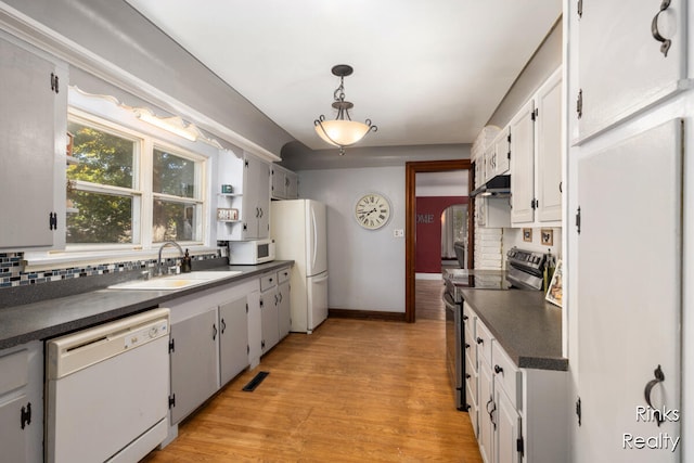 kitchen with white appliances, sink, pendant lighting, light hardwood / wood-style flooring, and white cabinets