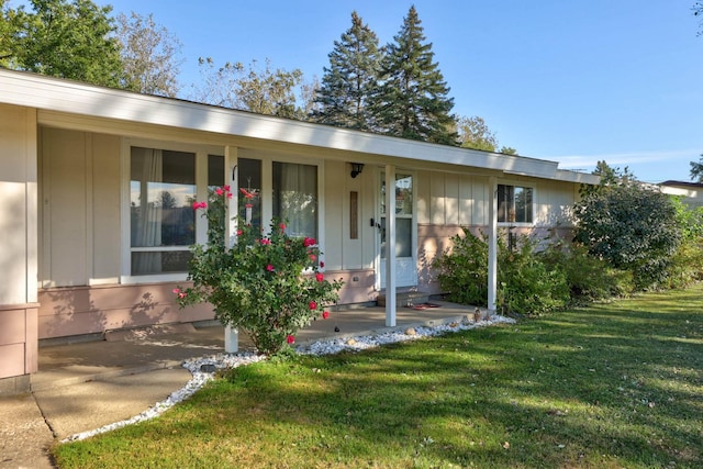 ranch-style home featuring a porch and a front lawn