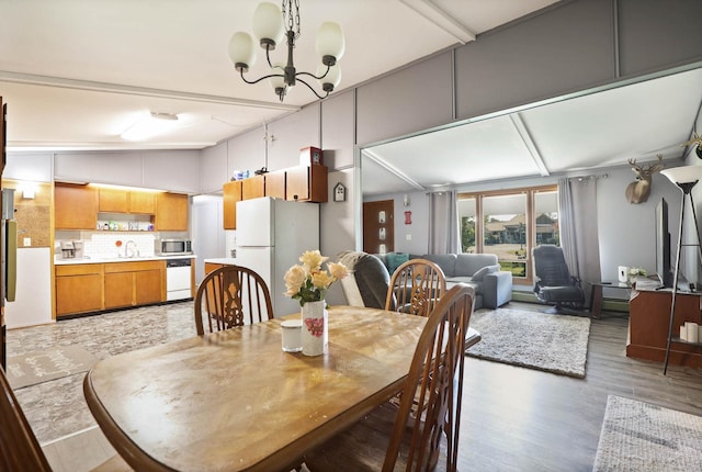 dining space featuring hardwood / wood-style floors, lofted ceiling, and an inviting chandelier