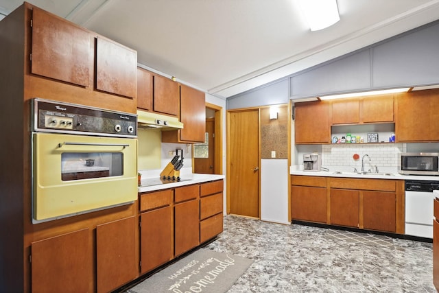 kitchen featuring black appliances, decorative backsplash, lofted ceiling, and sink