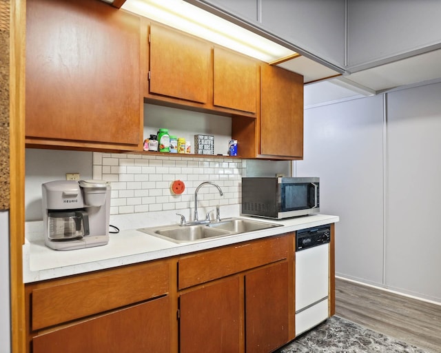 kitchen with backsplash, dishwasher, dark hardwood / wood-style floors, and sink