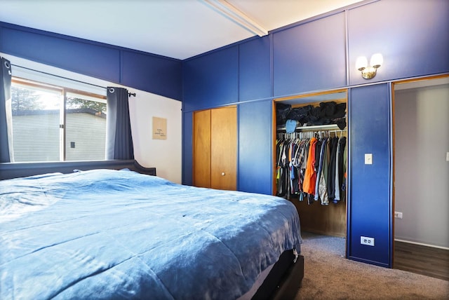 bedroom featuring dark colored carpet and multiple closets