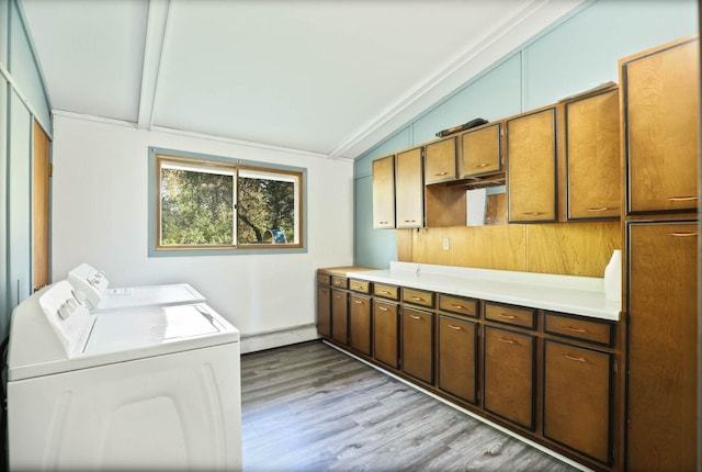 laundry area featuring washer and clothes dryer, cabinets, ornamental molding, a baseboard radiator, and light hardwood / wood-style floors