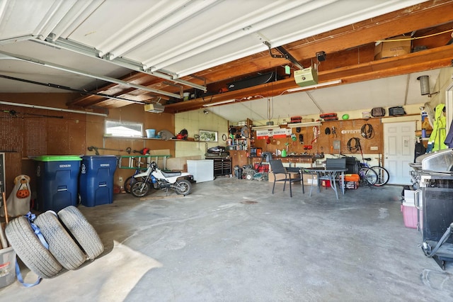 garage with a workshop area and a garage door opener