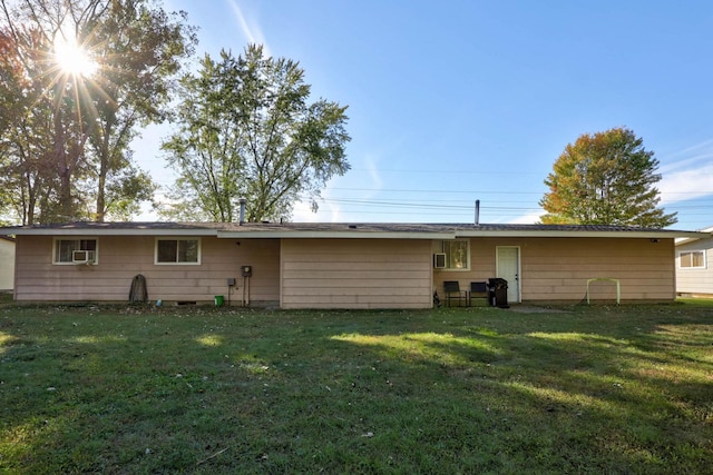 back of property with a lawn and cooling unit