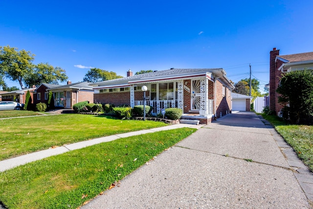 view of front of house with an outbuilding, a front lawn, covered porch, and a garage