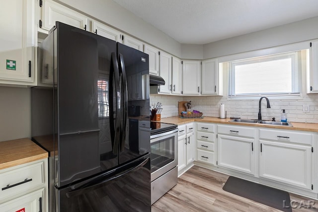 kitchen featuring black refrigerator, light wood-type flooring, sink, white cabinets, and stainless steel range with electric cooktop