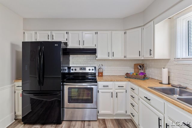 kitchen with black fridge, light hardwood / wood-style flooring, stainless steel electric stove, decorative backsplash, and white cabinets