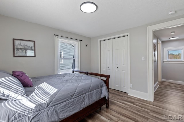 bedroom with hardwood / wood-style flooring, a textured ceiling, and a closet