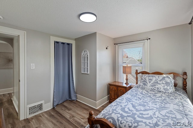 bedroom featuring hardwood / wood-style floors and a textured ceiling