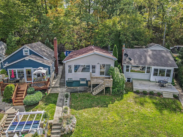 rear view of house with a deck, a yard, and a patio