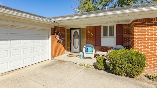 doorway to property with covered porch and a garage