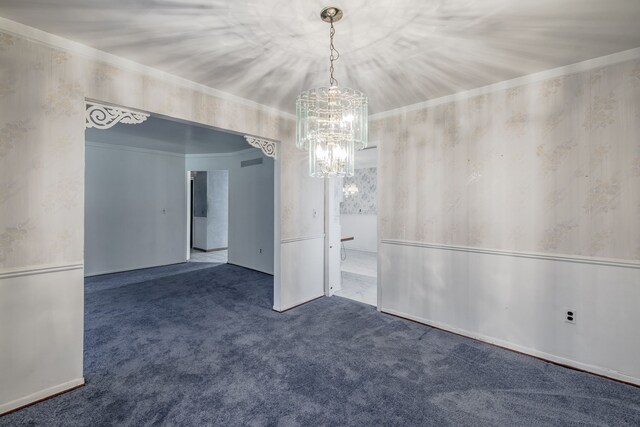 carpeted spare room featuring a chandelier and ornamental molding