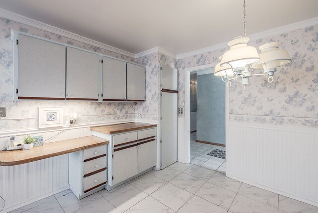 kitchen with wooden counters, gray cabinetry, crown molding, pendant lighting, and a notable chandelier