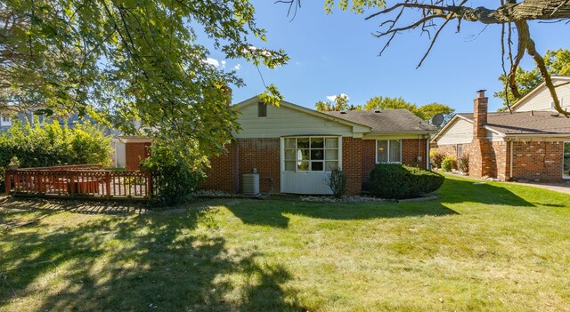 back of house with a wooden deck, cooling unit, and a lawn