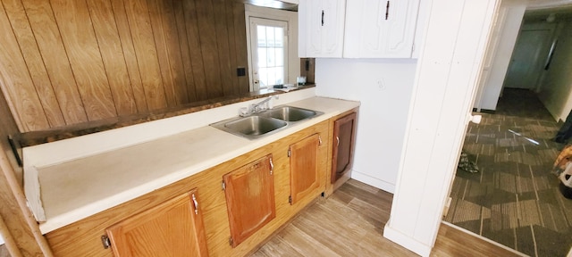 kitchen featuring white cabinetry, sink, and light hardwood / wood-style flooring