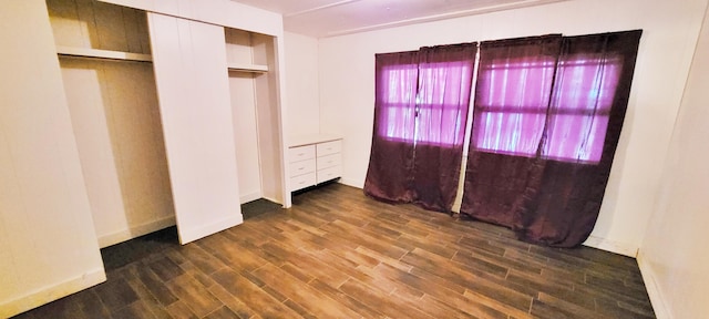 unfurnished bedroom with dark wood-type flooring