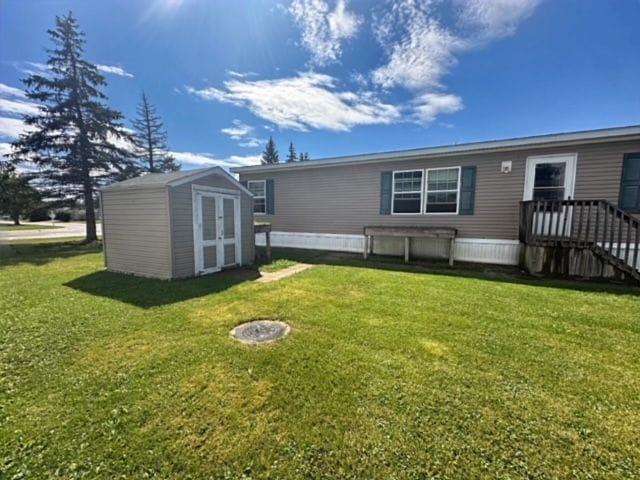 back of house featuring a yard and a storage unit