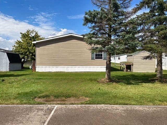 view of property exterior featuring a lawn and an outbuilding