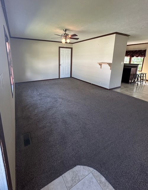 tiled spare room featuring ceiling fan