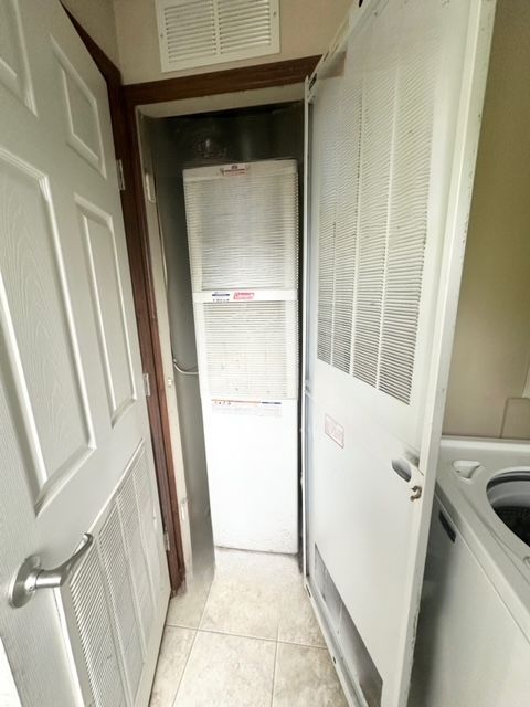 clothes washing area with light tile patterned floors