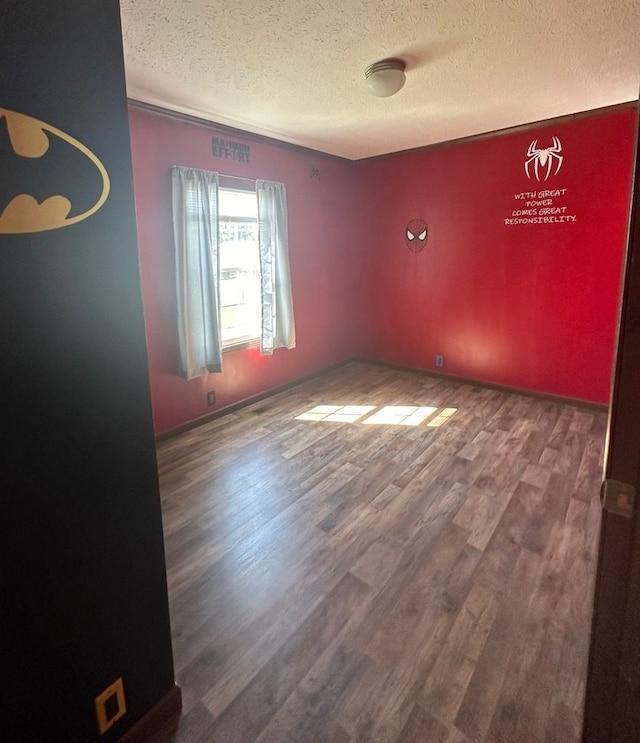 spare room featuring a textured ceiling and hardwood / wood-style flooring