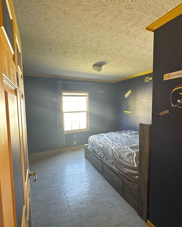 bedroom featuring ornamental molding and a textured ceiling