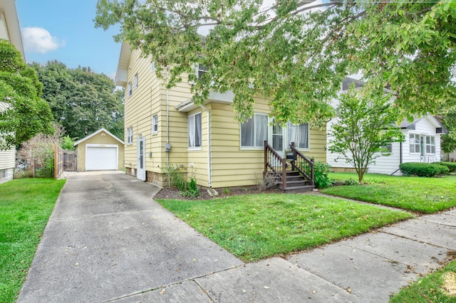 view of front of home featuring a garage, an outbuilding, and a front yard