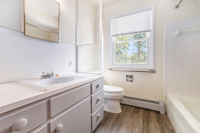 7080 Pine Island Dr NE, Comstock Park, MI 49321 - full bathroom with vanity, shower / tub combination, a baseboard heating unit, toilet, and wood-type flooring