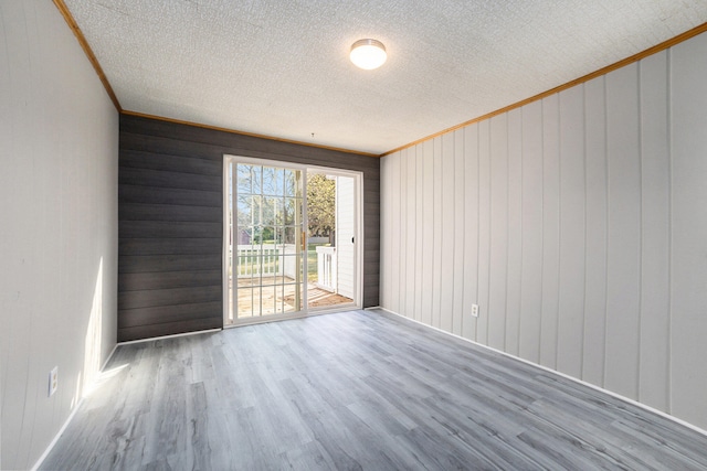7080 Pine Island Dr NE, Comstock Park, MI 49321 - spare room featuring hardwood / wood-style floors, ornamental molding, and wooden walls