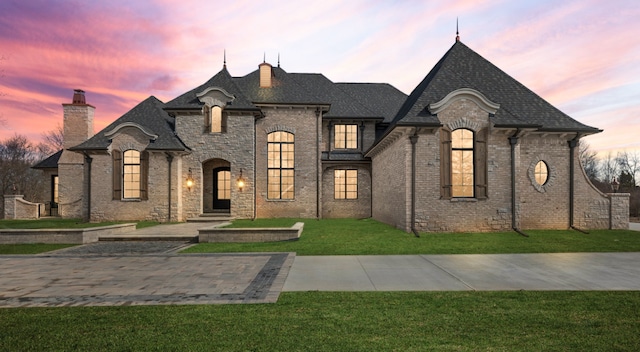 french country style house featuring a lawn