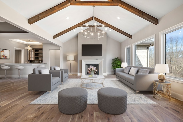 living room featuring hardwood / wood-style floors, lofted ceiling with beams, and a notable chandelier