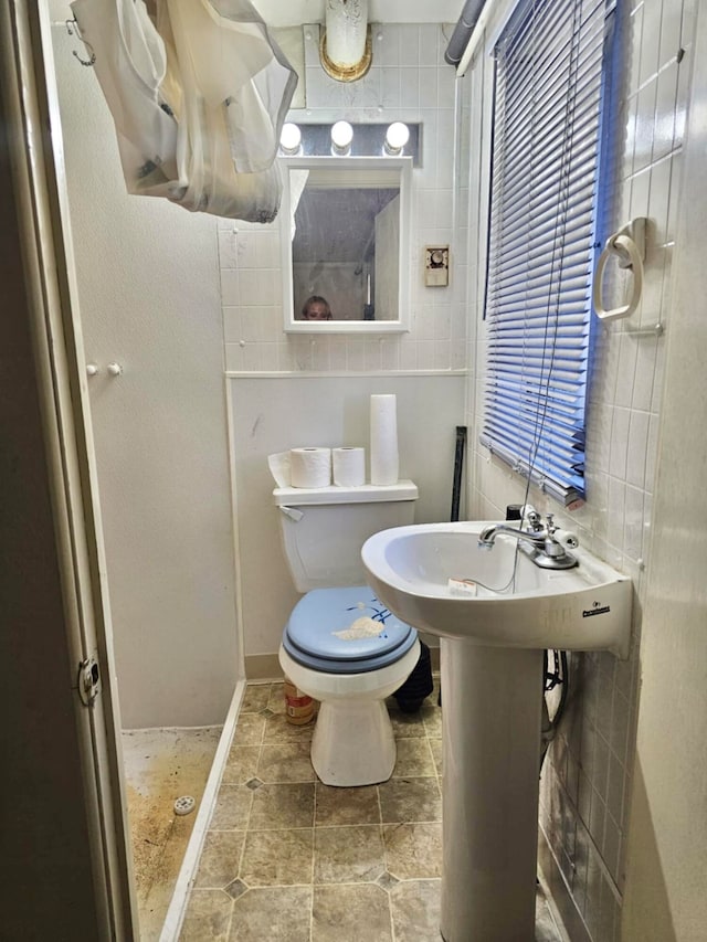 bathroom with tiled shower and toilet