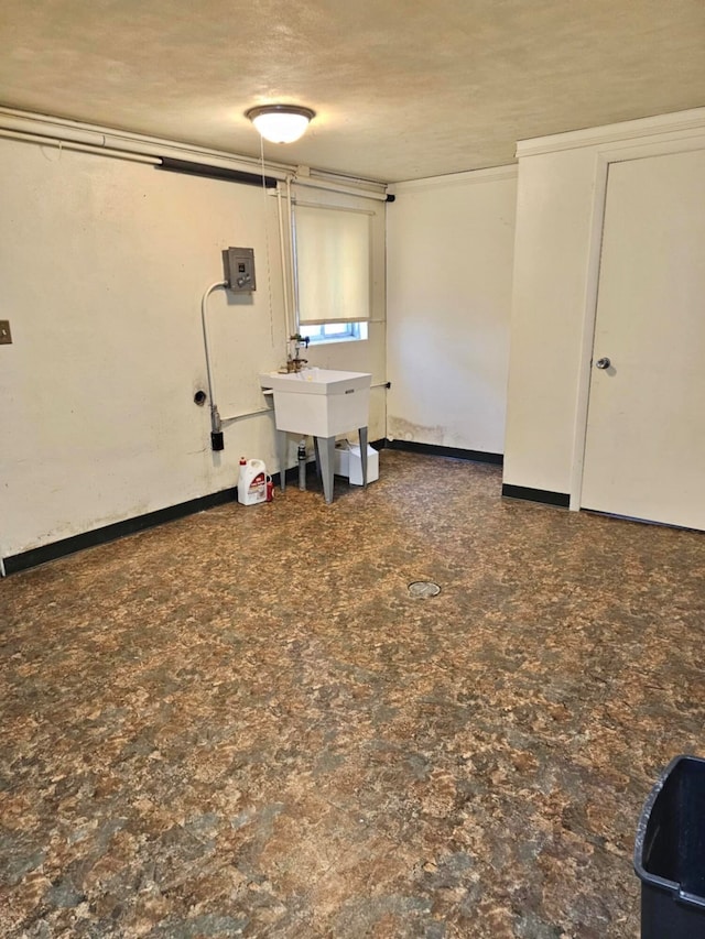 basement with a textured ceiling and sink