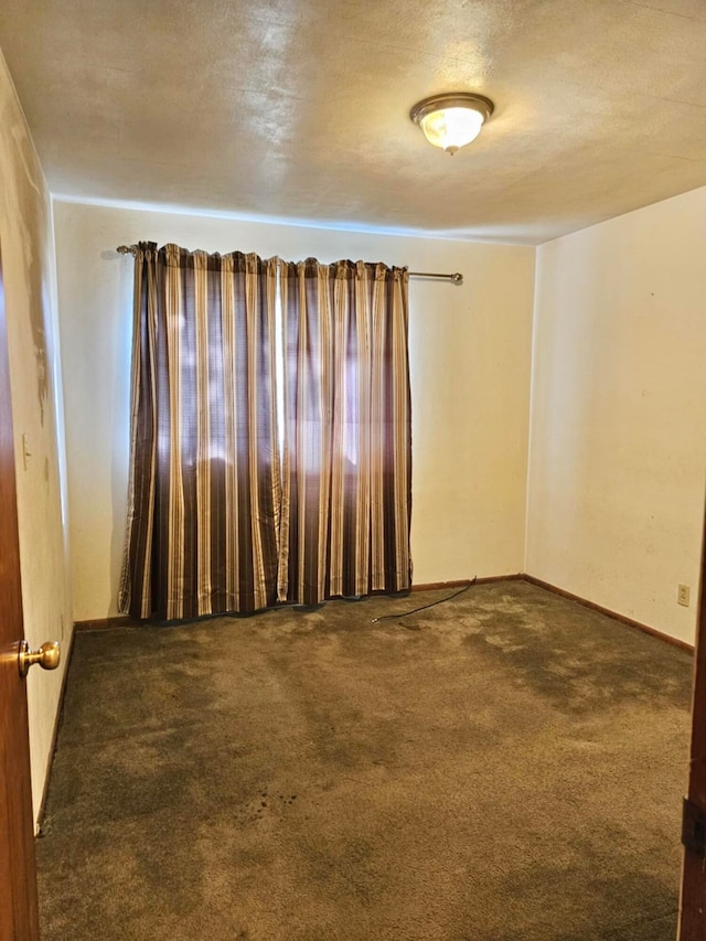 carpeted spare room with a textured ceiling