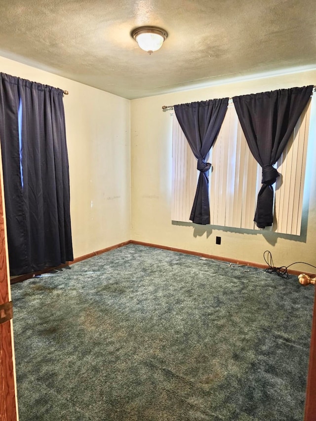 carpeted spare room with a textured ceiling